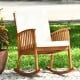 Acacia wood rocking chair with cream cushion, featuring a rustic design, perfect for outdoor patio relaxation.