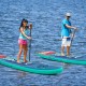 Two people paddle on 10 feet inflatable stand-up paddle boards, ideal for water activities like yoga and fishing.