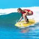 Young girl surfing on a lightweight bodyboard with EPS core, enjoying summer waves and outdoor water sports.
