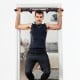 Multi-purpose pull-up bar in use, supporting up to 300lbs for indoor strength training and muscle building.