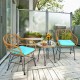 Cushioned rattan chair set with turquoise cushions and round glass table, perfect for outdoor patio relaxation.