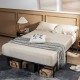 Full size folding steel platform bed frame with beige bedding, featuring under-bed storage and a modern design for.