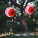 Two 3-foot Halloween inflatable eyeballs with red LED lights, creating a spooky atmosphere in a festive outdoor setting.