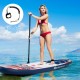 Inflatable stand up paddle board with a rider, featuring a non-slip grip and bungee system for safety on water.