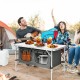 Height adjustable gray folding camping table with large storage area, perfect for outdoor picnics and barbecues.