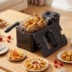 Electric stainless steel deep fryer with basket, cooking chicken, fries, and onion rings for delicious meals at home.