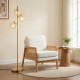 Mid-century modern accent chair with PE rattan armrests and 3-globe floor lamp in a cozy living room setting.