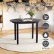 Close-up of the 43-inch round dining table with smooth black surface and rubber wood legs, designed for dining or.
