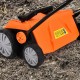 Electric scarifier in orange with removable blades and collection bag, showcasing wheels and adjustable height lever.