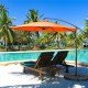 10FT orange offset umbrella with 8 ribs and cross base, providing adjustable shade for outdoor lounging by the pool.