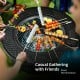 Outdoor fire pit with BBQ grill showcasing skewers and vegetables, perfect for casual gatherings in the backyard.