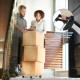 Portable folding stair climbing hand truck with three-wheel design and adjustable handle for easy transport of boxes.