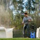 Electric pressure washer in blue, 2030 PSI, cleaning outdoor furniture with adjustable spray wand for versatile use.