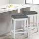 Set of 2 white nailhead saddle bar stools with soft upholstery and rubber wood legs, perfect for kitchen or dining.
