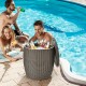 Rattan-style 9.5-gallon patio cool bar with drinks, serving as an ice bucket and side table by the pool.