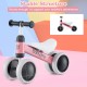 Toddler balance bike in pink with 4 wheels, soft seat, and anti-slip handlebars for safe indoor and outdoor riding.