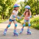 Two girls roller skating in a park wearing adjustable purple roller skates with light-up wheels and safety gear.