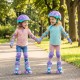 Two kids wearing purple adjustable roller skates with light-up wheels, holding hands while skating in a park.