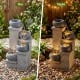 4-tier outdoor water fountain with cascading bowls and LED lights, showcasing a peaceful atmosphere for relaxation.