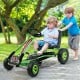 Kids pedal-powered go-kart in green with four rubber wheels, suitable for ages 3 to 8, for outdoor play and stability.