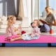 Bi-folding pink gymnastic tumbling mat with handles, ideal for kids' activities like crawling and yoga.