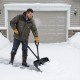 Man using a 53-inch snow shovel with assist handle to clear snow from a driveway, designed for easy lifting and.