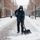 53-inch snow shovel with assist handle clearing snow on a brick pathway, ideal for driveways and patios.