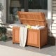 52-gallon patio wood deck box with flip top, ideal for cushions and outdoor storage, shown in a garden setting.