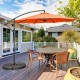 10FT orange offset umbrella with 8 ribs and cross base, providing adjustable shade for outdoor dining areas.