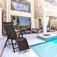 Adjustable rattan folding lounge recliner with a solid steel frame, perfect for outdoor patio relaxation by the pool.