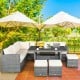 Sectional sofa set with off-white cushions, featuring rattan construction and a spacious table for outdoor dining.