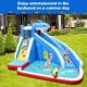 Inflatable Shark Bounce House with water slide and climbing wall, perfect for backyard fun on a summer day.