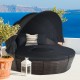 Black outdoor rattan daybed with retractable canopy and soft cushions, ideal for summer lounging by the pool or patio.