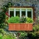 Wooden decorative planter box filled with vibrant plants, ideal for garden or window display, made from durable fir.