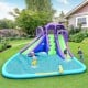 Inflatable water park with a large splashing pool, tall slides, and water cannon for backyard summer fun.