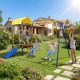 5-in-1 kids swing set in yellow featuring swings, trampoline, slide, and ladder for safe outdoor fun in the backyard.