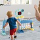 Toddler playing with a 5 in 1 sports toy featuring an adjustable basketball hoop, soccer, golf, and bowling activities.