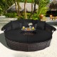 Round outdoor daybed with retractable canopy and soft black cushions, perfect for patio or poolside relaxation.