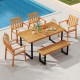 Patio dining set featuring a 63” acacia wood table, four armchairs, and a backless bench for outdoor gatherings.