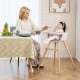 Convertible wooden highchair in light brown with safety harness, adjustable legs, and cozy PU cushion for mealtime.