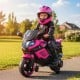 Kids motorcycle in pink with headlights, training wheels, and a comfortable seat for outdoor fun and safe driving.
