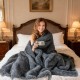 Soft plush gray faux wolf fur blanket draped on a bed, perfect for cozying up on sofas or armchairs.