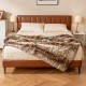 Soft plush fuzzy luxury faux raccoon fur blanket draped over a bed, ideal for cozying up on sofas and beds.