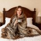 Luxurious 760GSM faux raccoon fur blanket draped over a bed, offering warmth and comfort for cozy moments.