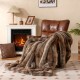 Soft plush fuzzy luxury faux fox fur blanket in brown draped over a chair, ideal for cozying up on sofas or beds.