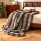 Soft plush fuzzy luxury faux fox fur blanket in brown, draped over a bed, ideal for sofas and armchairs.