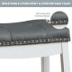 Close-up of the nailhead detail on a gray upholstered saddle bar stool with rubber wood legs for stylish comfort.