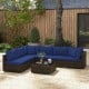 Sectional patio rattan sofa set with navy cushions and coffee table, perfect for outdoor relaxation in the garden.