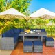 7-piece patio rattan dining furniture set with navy cushions, featuring a sectional sofa, table, and ottomans for.