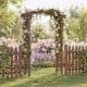 Wooden garden arch trellis in rustic brown, designed for climbing plants, ideal for weddings or patio entryways.